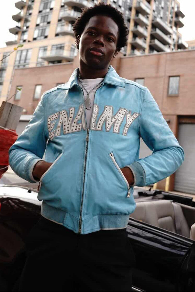 Person wearing a blue jacket with 'ENEMY' text, standing outdoors with buildings in the background