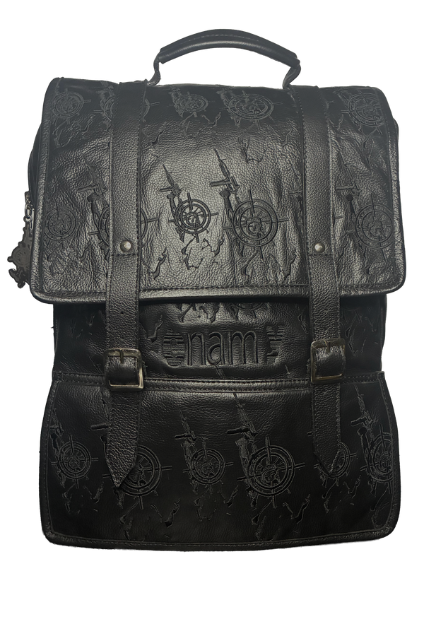 Front view of black genuine leather backpack with embossed Veil For Liberty monogram flap closure and brass buckles. Maison Enamy NYC. 17x13 inches.